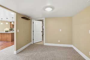 Empty room with light carpet and a textured ceiling