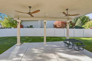 Fenced backyard with ceiling fan and a patio
