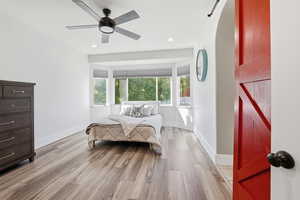 Bedroom with light wood-style floors, a barn door, ceiling fan, and recessed lighting