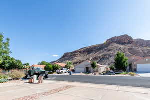 View of asphalt driveway featuring sidewalks and a mountain view