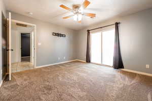Unfurnished room featuring a textured ceiling, ceiling fan, and light carpet