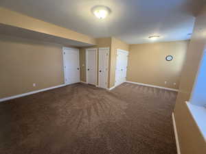 Below grade area with baseboards and dark carpet