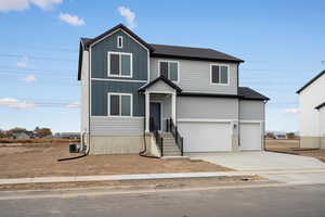 View of front of house with concrete driveway, board and batten siding, a garage, and a shingled roof