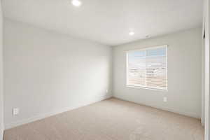 Spare room with light carpet and recessed lighting