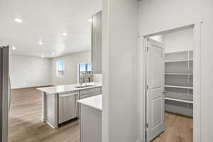 Kitchen with light wood-type flooring, appliances with stainless steel finishes, recessed lighting, a peninsula, and open floor plan