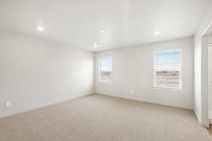 Spare room featuring light colored carpet and recessed lighting