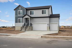 View of front of home with driveway, a garage, board and batten siding, and a shingled roof