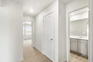 Hallway featuring light colored carpet and recessed lighting