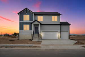View of front facade featuring board and batten siding, concrete driveway, and an attached garage
