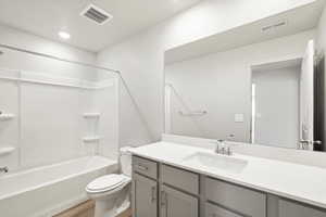 Bathroom featuring bathing tub / shower combination, vanity, a textured ceiling, light wood-type flooring, and recessed lighting