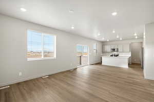 Unfurnished living room with recessed lighting and light wood-type flooring
