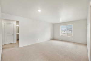 Unfurnished room with light colored carpet and recessed lighting