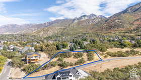 Aerial view of property and surrounding area featuring a mountain backdrop and property parcel outlined