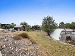 View of grassy yard featuring an outdoor structure and an exterior structure
