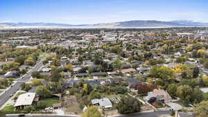 Aerial view of property and surrounding area with a mountainous background and nearby suburban area