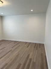 Unfurnished room with a textured ceiling, wood finished floors, and recessed lighting
