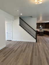 Unfurnished living room with stairway, dark wood finished floors, a textured ceiling, and recessed lighting