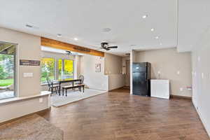 Kitchen featuring wood tiled floors, freestanding refrigerator, recessed lighting, a ceiling fan, and a textured ceiling