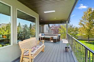 Deck with an outdoor living space and a lawn