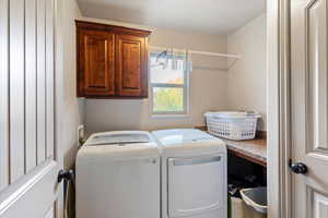 Laundry room featuring cabinet space and independent washer and dryer