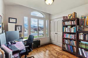 Office space featuring light wood-style flooring and a textured ceiling