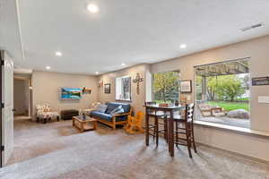 Living area featuring light colored carpet and recessed lighting