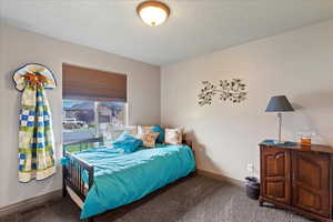 Bedroom featuring carpet flooring and a textured ceiling