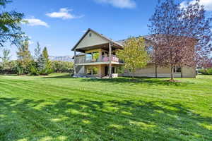 Back of property with stairs, a yard, and a patio