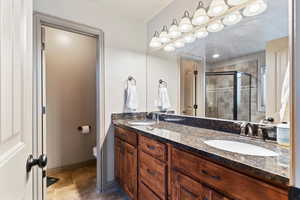 Full bathroom featuring double vanity and a shower stall