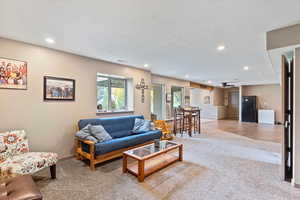 Living room with light colored carpet and recessed lighting