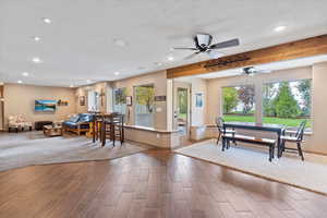 Dining area with beamed ceiling, wood tiled floors, recessed lighting, ceiling fan, and a textured ceiling