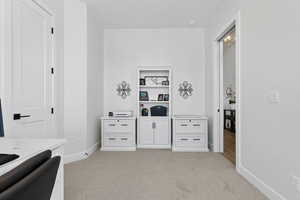 Home office with light carpet and baseboards