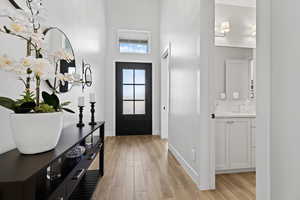 Foyer entrance featuring light wood-style flooring and a high ceiling