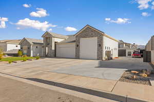 Single story home with a residential view, driveway, an attached garage, stucco siding, and stone siding