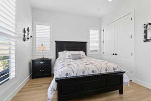 Bedroom with light wood-style flooring and a closet
