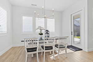 Dining room with light wood-style floors and a chandelier