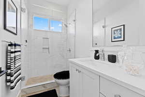 Bathroom with vanity and a marble finish shower