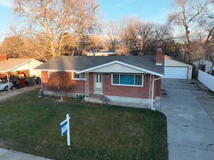 Single story home featuring brick siding, a front yard, and a chimney