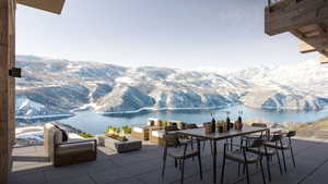 View of patio / terrace with outdoor dining space, a water and mountain view, and a fire pit