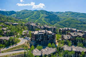 Aerial view of property and surrounding area featuring a mountainous background
