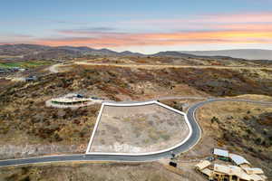Aerial view at dusk of a mountain view, property parcel outlined, a desert view, and a rural view