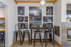 Bar featuring wood finished floors and black fridge