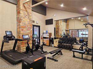 Exercise room featuring high vaulted ceiling
