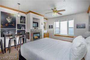 Bedroom with a lit fireplace and ornamental molding