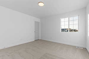 Unfurnished room featuring light colored carpet and baseboards