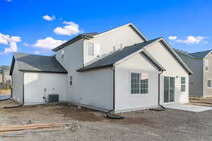 Rear view of property with stucco siding, a patio, and a shingled roof