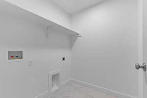 Laundry area with hookup for a washing machine, electric dryer hookup, and light marble finish floors