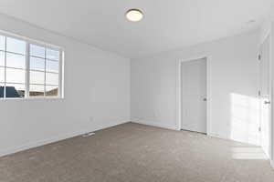 Empty room with light carpet and baseboards