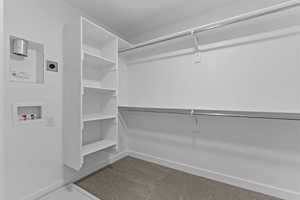 Walk in closet with light colored carpet