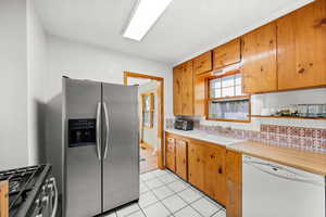 Knotty Pine Kitchen with tile countertops, floor, and backsplash